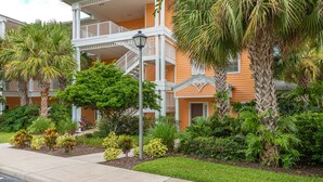 A two-story hotel with a balcony, surrounded by lush greenery and palm trees. - Bahama Bay Highest Rated, best Location 3BR/2Bath, Recently Renovated 3rd Floor (Davenport)