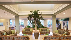 A spacious lobby with wicker furniture, a large central plant, and a Marketplace sign. - Bahama Bay Highest Rated, best Location 3BR/2Bath, Recently Renovated 3rd Floor (Davenport)
