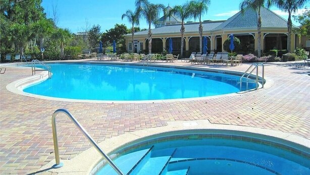A swimming pool with a brick deck, palm trees, and a covered pavilion. - Bahama Bay Highest Rated, best Location 3BR/2Bath, Recently Renovated 3rd Floor (Davenport)