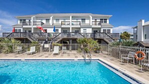 A multi-story hotel with a swimming pool, outdoor seating, and a lifeguard stand. - Beautiful Town Home Beach Rental In Perdido Key Florida - Pool + Beach Access (Perdido Key)