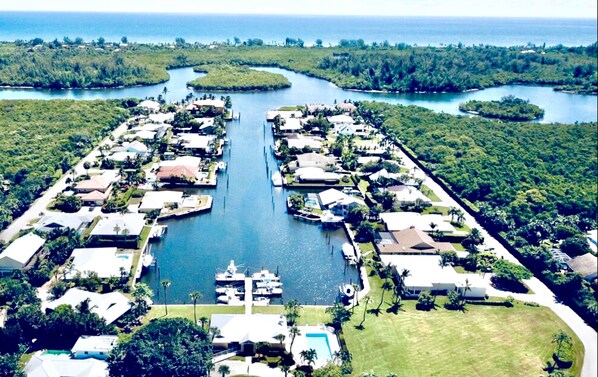 Residential properties line the tranquil waterway, surrounded by lush greenery.