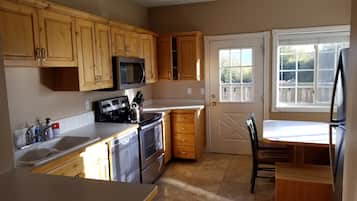 Enjoy meals in this kitchen with a dining table and chairs, a sink, and a stove.