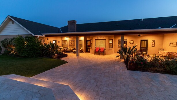 A two-story house with a covered patio area, a brick driveway, and a well-maintained lawn. - Hidden, Lush Treasure Close to Everything...Your Own Private Resort! (Mesa)