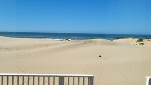 En sandstrand med en klarblå himmel och ett hav.