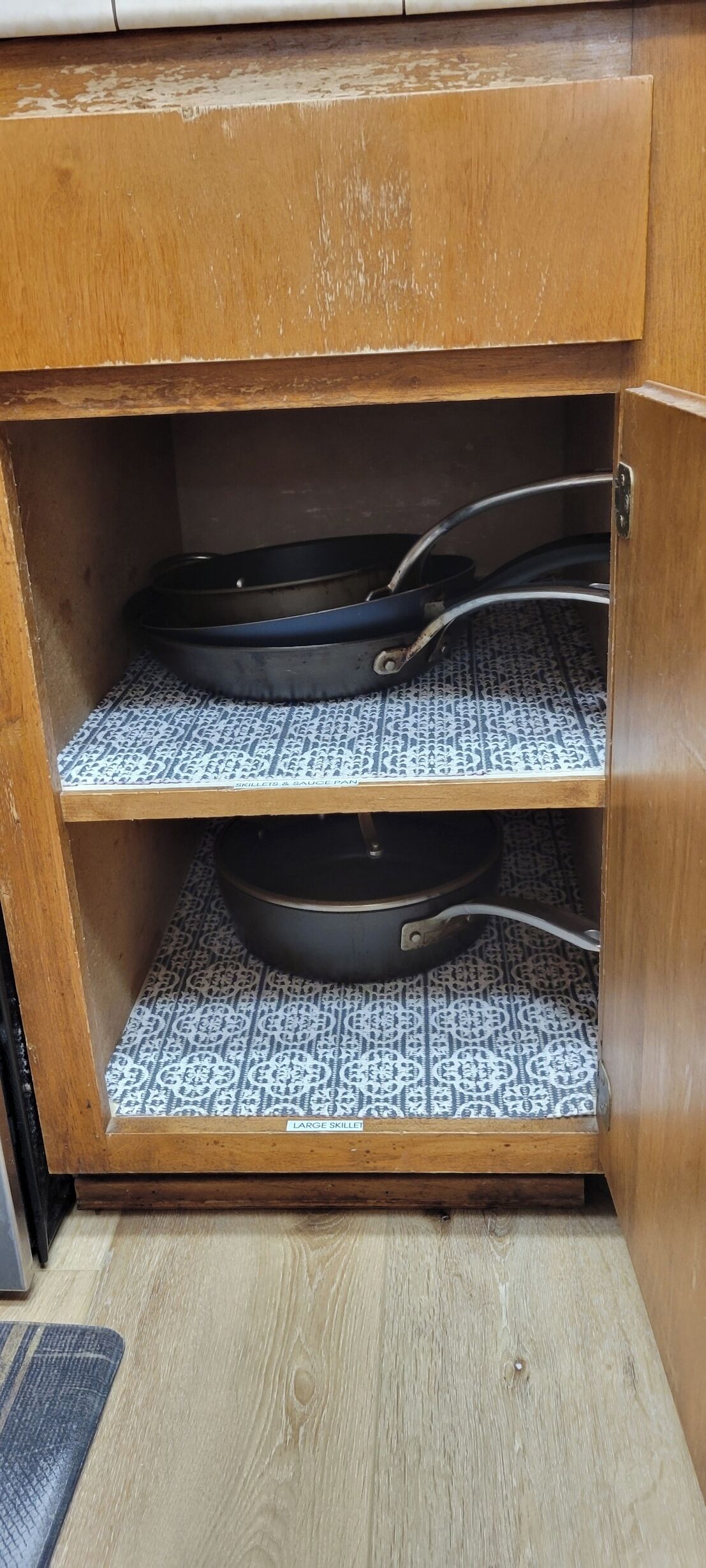 Un armario de madera con dos estantes que contiene utensilios de cocina.