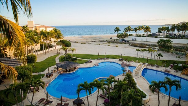 A resort with a large pool, palm trees, and a beach view. - Las Mañanitas LM E3402 (Los Cabos)