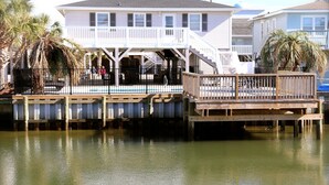 A waterfront house with a wooden dock and a balcony. - WATER FRONT, PRIVATE POOL, PET FRIENDLY, WIFI, OUTDOOR PARADISE! (North Myrtle Beach)