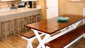 A kitchen with wooden cabinets, a microwave, and a wooden dining table with benches. - WATER FRONT, PRIVATE POOL, PET FRIENDLY, WIFI, OUTDOOR PARADISE! (North Myrtle Beach)