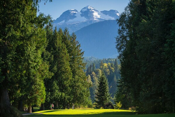 A golf course with a mountain backdrop. - Premier Silverbear Penthouse Condo - Hot tub, spacious, wrap around deck (Revelstoke)