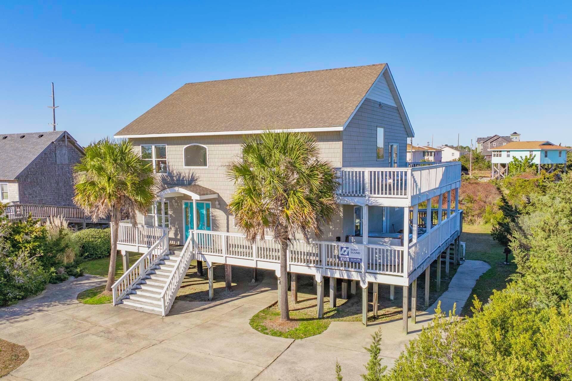 A two-story house with a balcony and a covered porch.