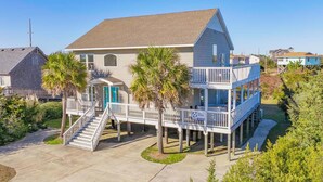 A two-story house with a balcony and a covered porch. - Oceanside Dog Friendly Home w/ Hot Tub, Game Room, and Beach Nearby (Salvo)