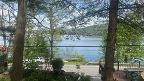 Une vue sur le lac, avec des arbres, une terrasse en bois et une table de pique-nique.