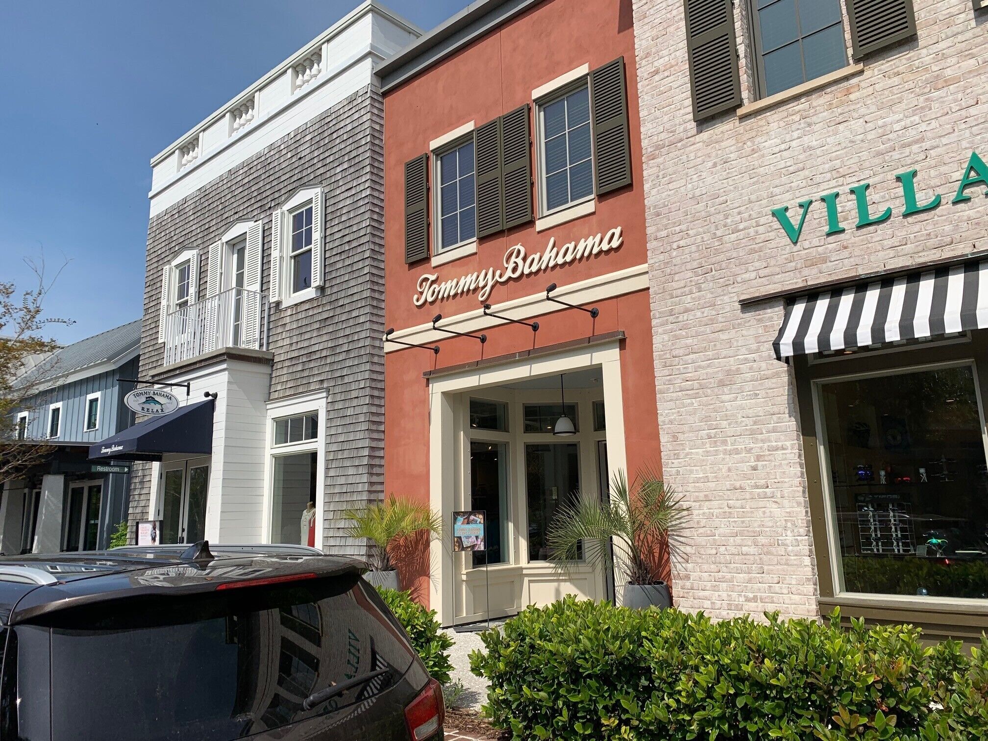 A Tommy Bahama branded building with a red facade and a black and white awning.