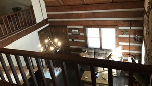 A wooden interior with a staircase, a chandelier, a sofa, and a window with blinds. - The Cabin at Flat Rock Farms - rustic charm on a beautiful former horse farm  (Lewisburg)