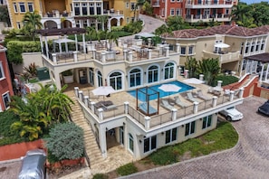 Un immeuble à plusieurs étages doté d’une piscine sur le toit, d’un espace extérieur aménagé et d’un patio couvert.