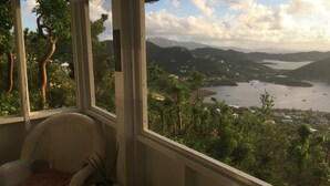 Une chambre avec vue sur un lac, des montagnes et des arbres.