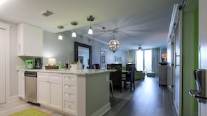A modern kitchen with white cabinets, a central island, and pendant lighting.