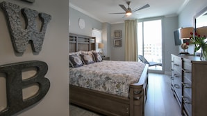 A bedroom with a bed, a dresser, a ceiling fan, and a window with curtains.