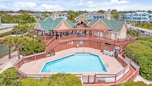 A large pool with a wooden deck and a covered area with a railing. - Beautiful Southport, Golf Frontage & Oak Island Beach club .New Quartz counters  (Southport)
