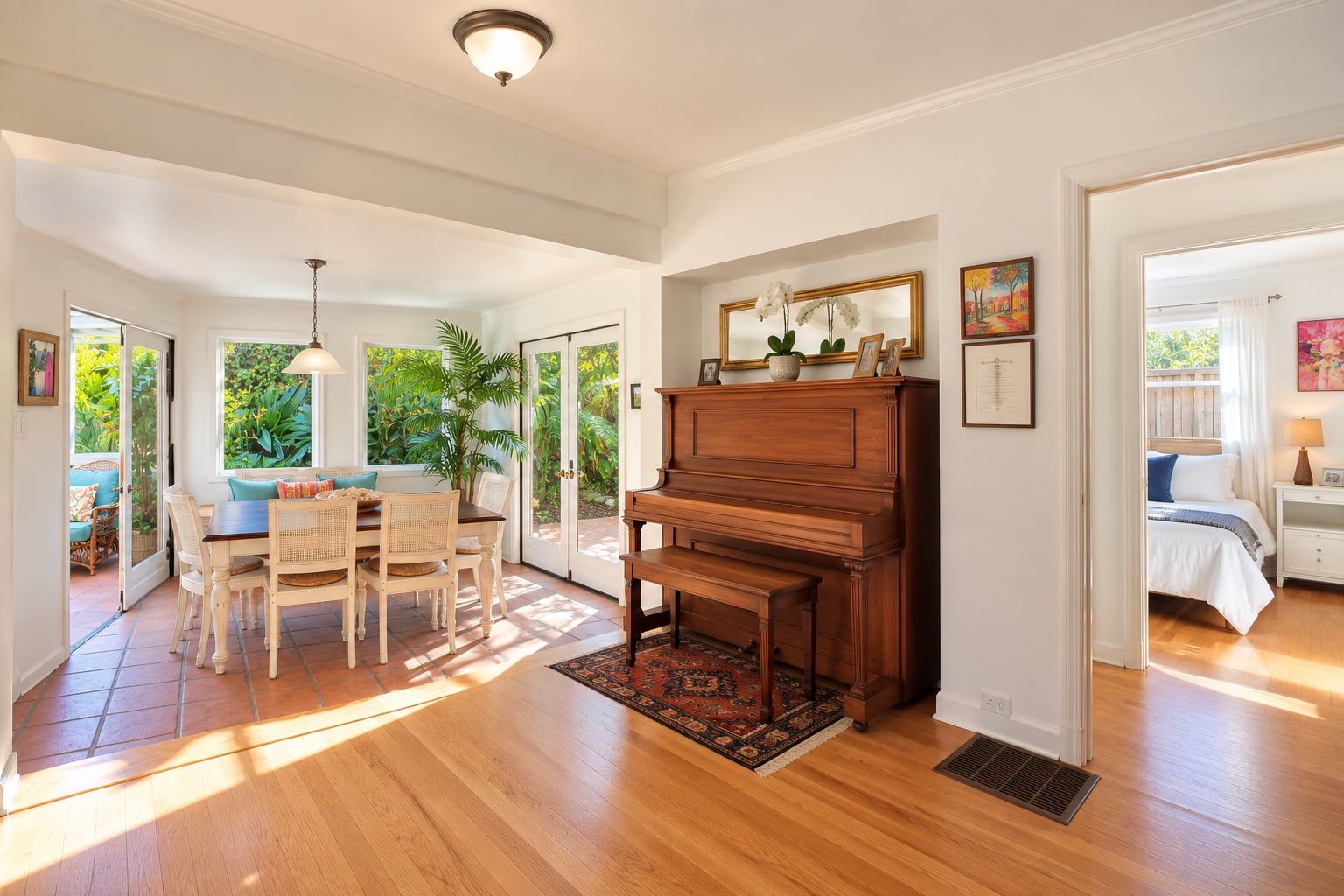 Un vaste salon agrémenté d’un piano en bois, un coin repas avec des chaises en osier et une grande fenêtre donnant sur un paysage verdoyant.