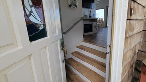 A wooden staircase leading to a kitchen area with a dining table and chairs.