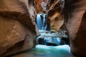 A narrow canyon with a waterfall and a ladder leading down. - Coral Ridge Retreat 1! Right Across the Street from Pools! (Washington)