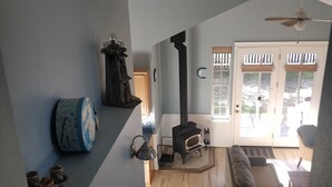 A staircase leading to a living area with a fireplace, a sofa, and a ceiling fan.