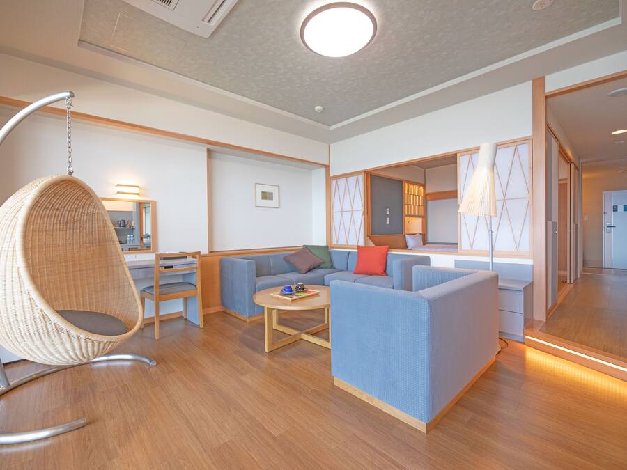 A modern living room with a hanging chair, sofas, and a coffee table.