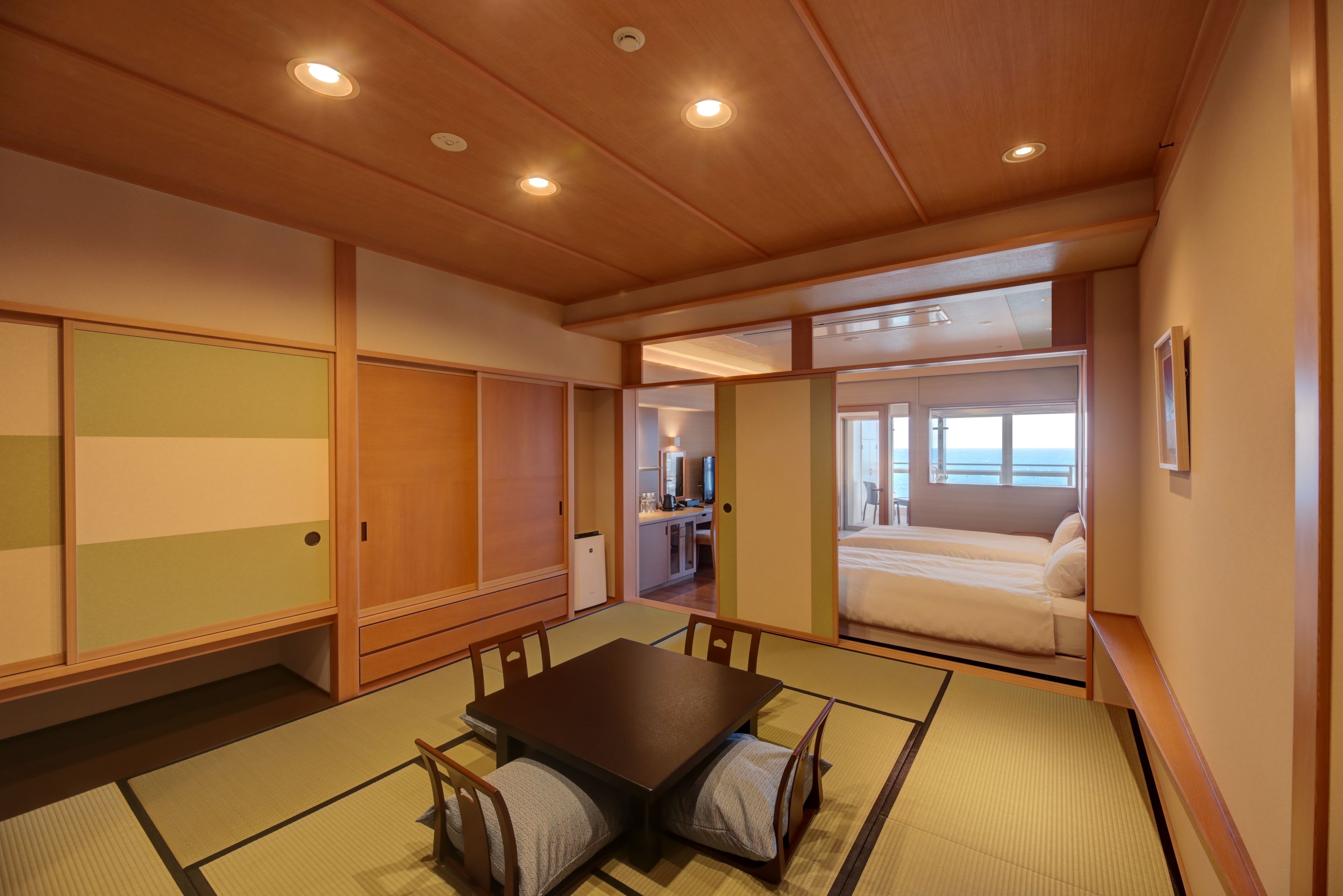 A traditional Japanese-style room with tatami flooring, a low wooden table, and sliding doors.