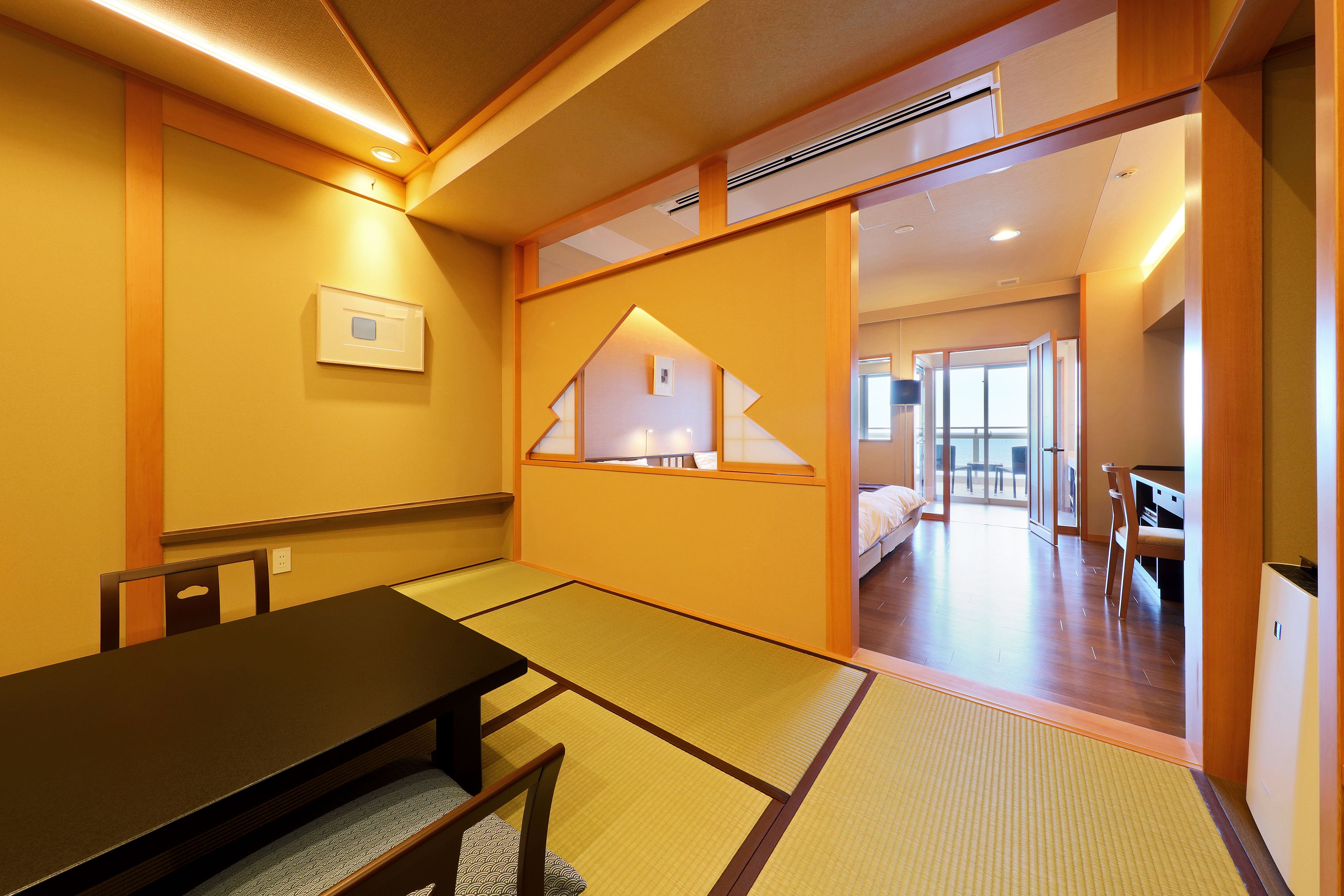 A traditional Japanese room with tatami flooring, a low table, and a bed.
