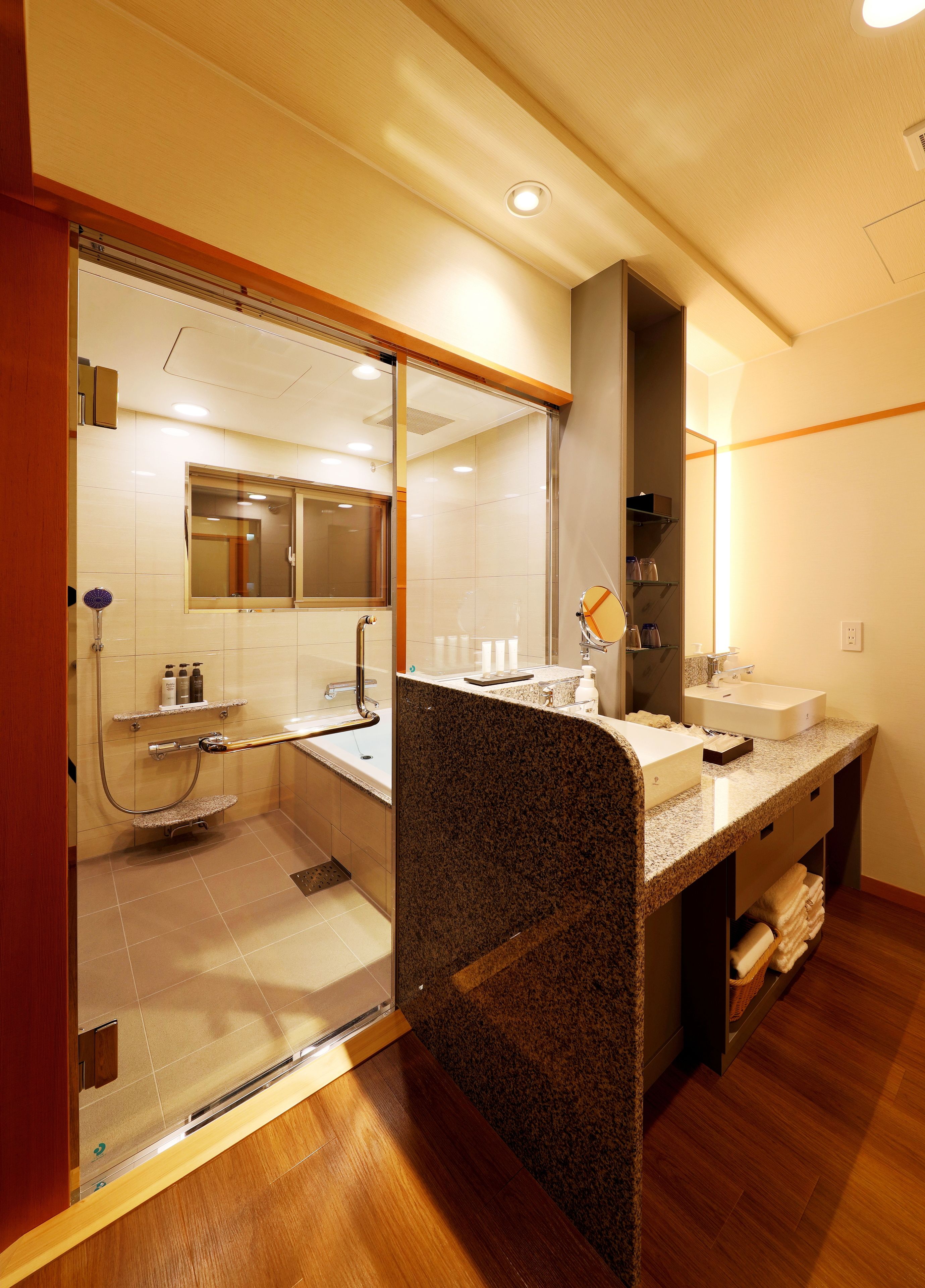 A modern bathroom with a glass shower enclosure, a vanity with a sink, and a mirror.