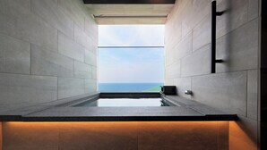 A modern bathroom with a built-in window, a countertop, and a wall-mounted light fixture.