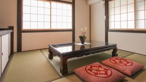 A traditional Japanese room with tatami flooring, a low wooden table, and shoji screens.