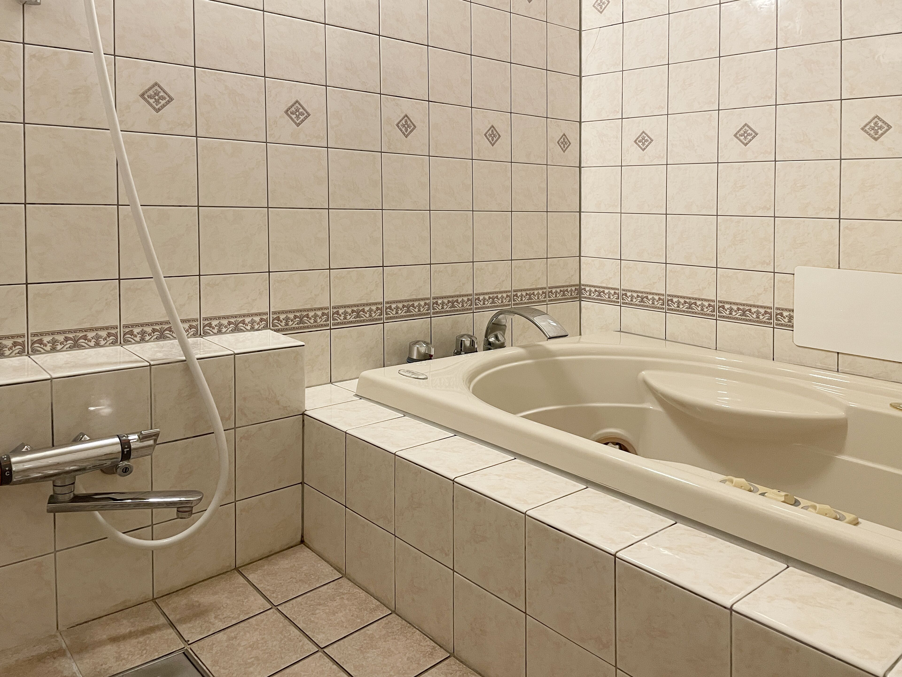 A bathroom with a bathtub, shower, and a toilet.