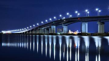 Vista nocturna de un puente con luces reflejándose en el agua.