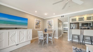 A modern kitchen with white cabinets and a dining area with a round table and chairs.