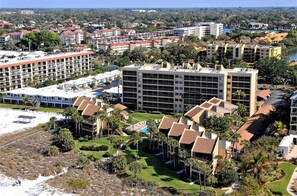 A resort with multiple buildings, a pool area, and a beach.