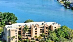 Un hôtel à plusieurs étages, doté de balcons, situé près d’une étendue d’eau.