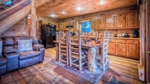 Un interno in legno con divano, tavolo da pranzo e angolo cottura.