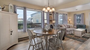 Un salón amplio con comedor, ventanas grandes y vistas al barrio.