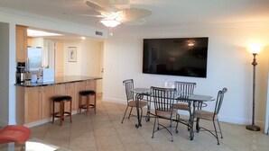 Une cuisine moderne avec un coin bar, une table à manger et des chaises.