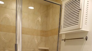 Une salle de bain comprenant une douche à parois de verre, des toilettes, un bidet et un lavabo.