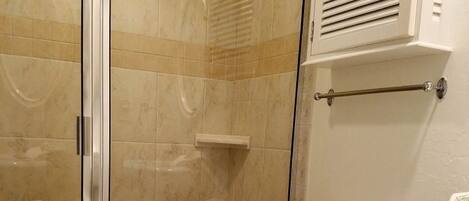A bathroom with a glass-enclosed shower, a toilet, a bidet, and a sink.