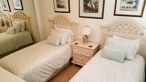 Une chambre d’hôtel avec deux lits, une table de chevet et une petite table.