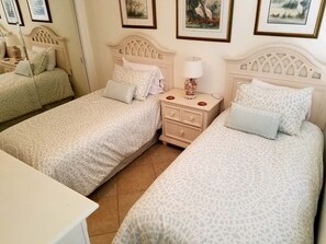Une chambre d’hôtel avec deux lits, une table de chevet et une petite table.
