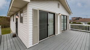 A single-story house with a covered porch, sliding glass doors, and a small deck area. - 385 Cute 3 Bedroom Cottage in South Nags Head (Nags Head)