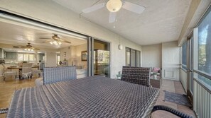 Ein geräumiges Schlafzimmer mit einem großen Bett, einem Deckenventilator und Blick ins Freie.