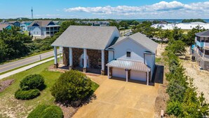 A residential property with a stone facade, a covered porch, and a garage. - 632 Private Pool, Hot Tub, Billiards, and More! (Corolla)