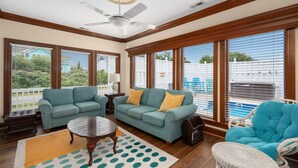 A living room with a ceiling fan, two sofas, a coffee table, and large windows with blinds. - 632 Private Pool, Hot Tub, Billiards, and More! (Corolla)