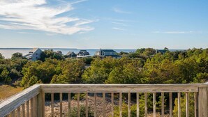 A coastal residential area with houses, a wooden deck, and a view of the sea.